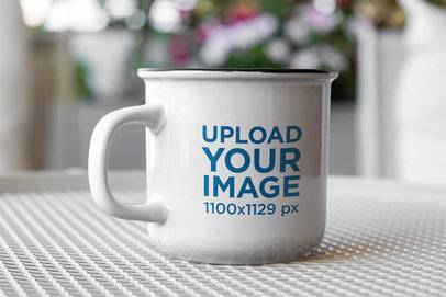 Mockup of a 12 oz Enamel Coffee Mug over a Textured Surface