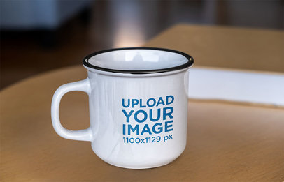 Mockup Featuring a Customizable Enamel Mug Placed on a Wooden Table