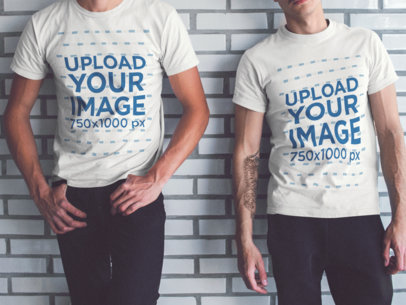 Two Guys Wearing Different T-Shirts Mockup While Lying Cropped Faced Against a White Bricks Wall