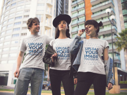 Three Young Friends Wearing Different T-Shirts Mockup While in the City