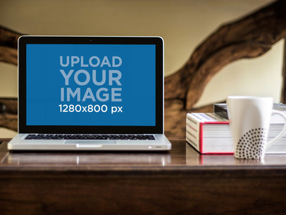 Mockup of a MacBook Pro Next to Books on a Desk