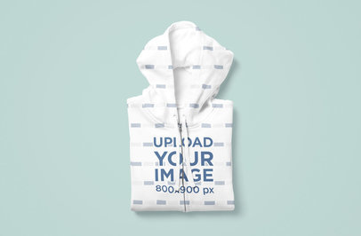 Mockup of a Sublimated Hoodie Folded Over a Flat Colored Surface
