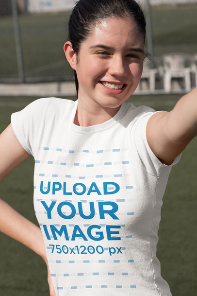 T-Shirt Mockup of a Happy Teenager Taking a Selfie at a Soccer Field 