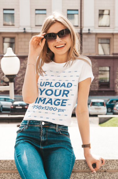 T-Shirt Mockup Featuring a Joyful Woman With Sunglasses Posing in the City 