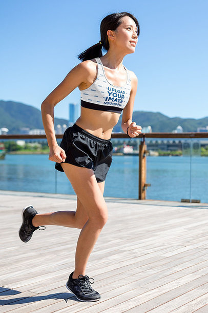 Sports Bra Mockup Featuring a Happy Woman Running by a Lake