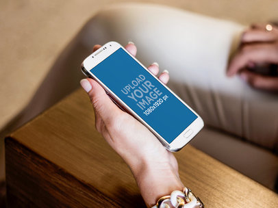 Samsung Galaxy S4 Held By A Woman Sitting on a Bench