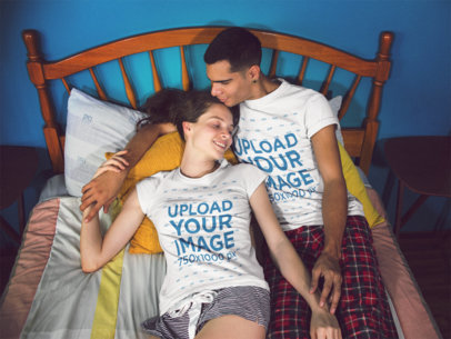 Young Couple Lying on Their Bed Holding Hands and Smiling While Wearing Tshirts Template with Different Designs a15713
