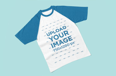 Mockup of a Raglan Tee Laying Flat on a Customizable Surface