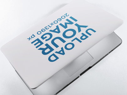 Mockup of a Laptop Cover on a Closing MacBook Lying on a Solid Color Surface