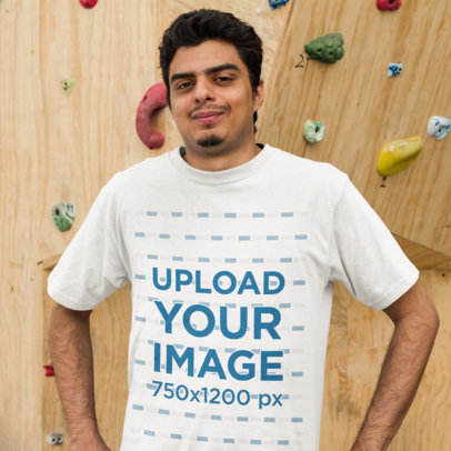 Young Man Wearing a Round Neck Tee Mockup while Standing Against a Climbing Wall