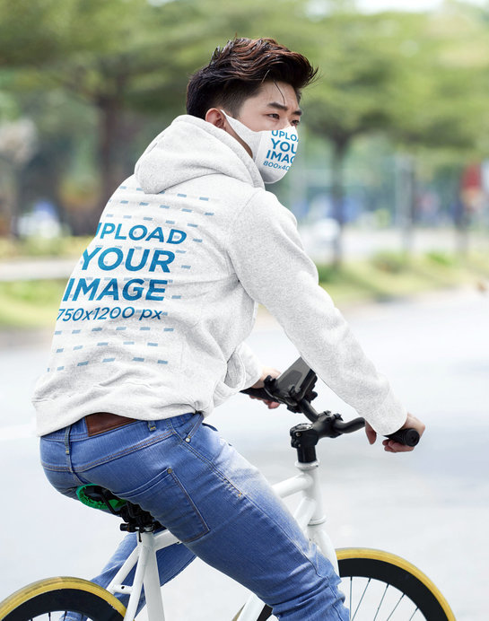 Back-View Hoodie Mockup of a Man on a Bike Wearing a Face Mask