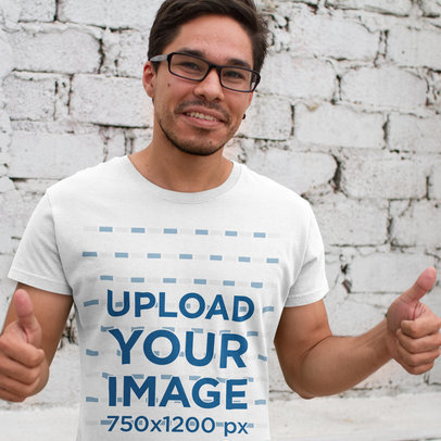 Smiling Young Hispanic Man Wearing a Round Neck Tee Template and Glasses Against a White Bricks Wall