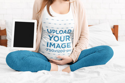 T-Shirt Mockup Featuring a Pregnant Woman Sitting on Her Bed