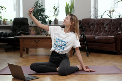 T-Shirt Mockup of a Woman Taking a Selfie After an Indoor Yoga Session