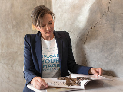 Woman Reading a Magazine While Wearing a Tshirt Mockup Inside a Concrete Room a15771