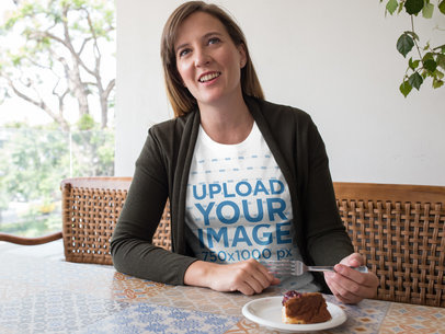 Smiling Woman Wearing a Round Neck T-Shirt Mockup While Eating Dessert at a Restaurant a15773