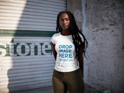 Mockup of a Woman With her Hands Behind Her Back Wearing a Round Neck T-shirt on the Street 15554