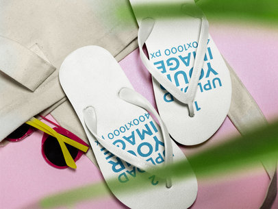 Two Flip Flops Mockup Lying on a Pink Surface Near a White Towel