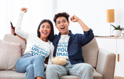 Long Sleeve T-Shirt Mockup of a Young Couple Celebrating While Watching TV