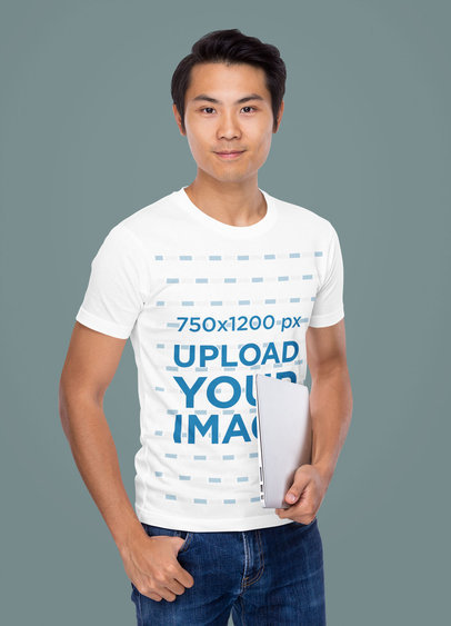 T-Shirt Mockup of a Man Holding a Laptop in a Studio