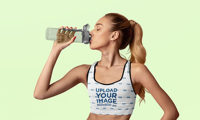 Sports Bra Mockup of a Young Woman Drinking Water in a Studio