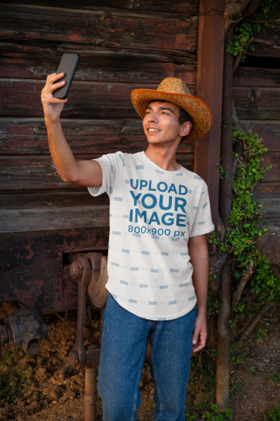 Sublimated T-Shirt Mockup of a Happy Man Taking a Selfie by an Old Train Wagon 