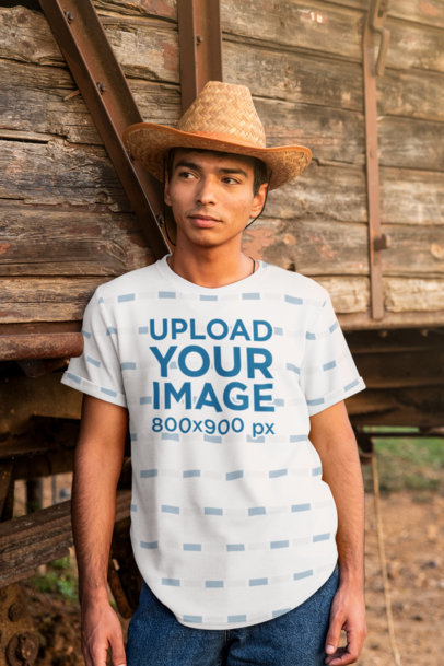 Mockup of a Serious Man With a Sublimated T-Shirt Posing By an Old Train Wagon 