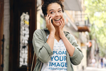 T-Shirt Mockup of a Happy Woman Talking on the Phone on the Street