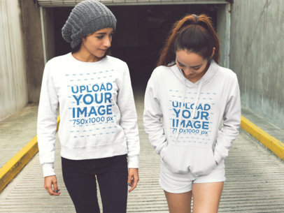 Mockup of Two Women Coming Out of a Tunnel Wearing a Crewneck Sweatshirt and a Pullover Hoodie