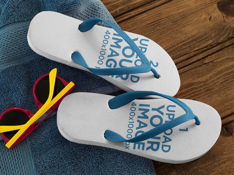 Two Flip Flops Template Lying on a Blue Towel on a Wooden Seat
