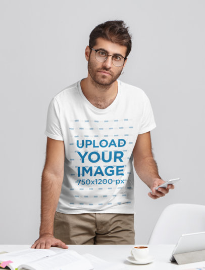 T-Shirt Mockup Featuring a Young Man With Glasses in a Studio Setting