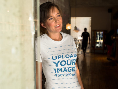 Smiling Middle Aged Woman Lying Against a Wall While Wearing a T-Shirt