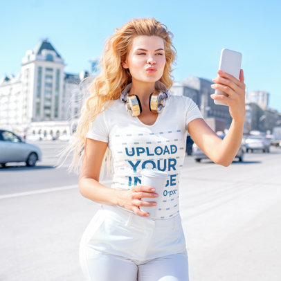 T-Shirt Mockup of a Blonde Woman Taking a Selfie on the Street 