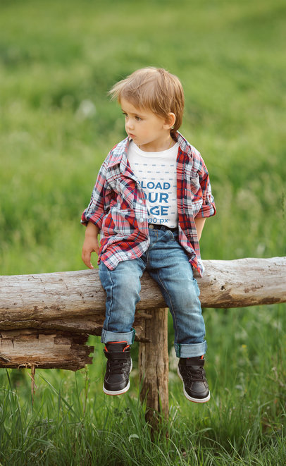 T-Shirt Mockup of a Plaid-Wearing Boy Sitting on a Log