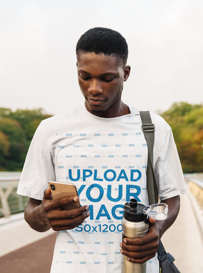 T-Shirt Mockup of a Young Man Checking His Phone After Training
