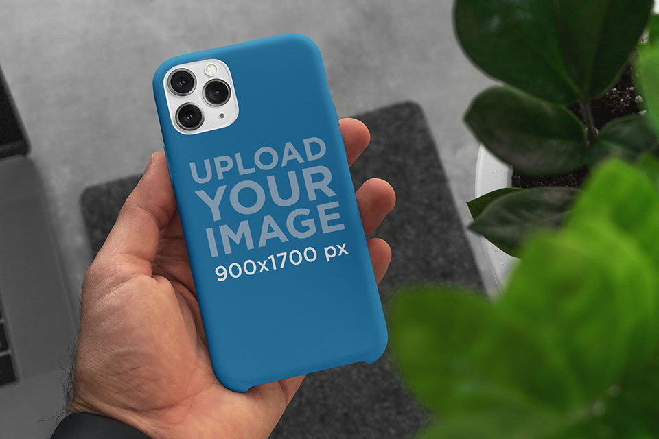 Mockup of a Man Holding a Phone Case in His Hand