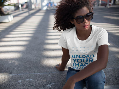 Woman Wearing Sunglasses and a T-Shirt Template While Facing the Wind Sitting Down on the Street