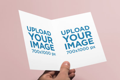 Mockup Featuring a Man's Hand Holding a Customizable Greeting Card 