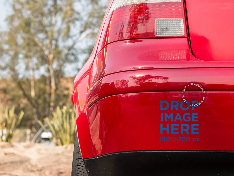 Placeit - Square Sticker Mockup in the Back Bumper of a Red Car