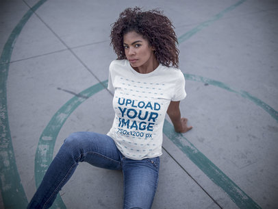 Mockup of a Young Woman wearing a Round Neck Tee While Lying in a Basketball Court 