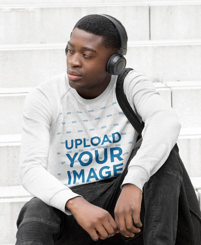 Sweatshirt Mockup of a Man Sitting on Some Steps with His Headphones On