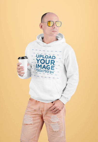 Hoodie Mockup of a Man Posing with a Coffee in Hand