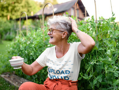 T-Shirt Mockup Featuring a Happy Senior Woman in Her Cottage Backyard