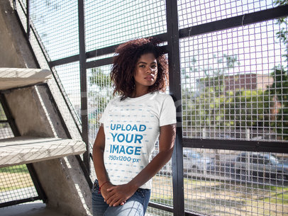 Mockup of a Woman Wearing a T-shirt While Lying Against a Fence 15809