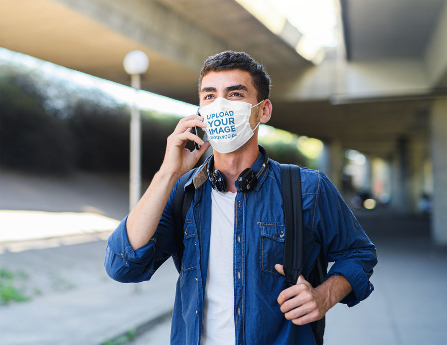 Face Mask Mockup of a Man Talking on the Phone While Waking in the Street