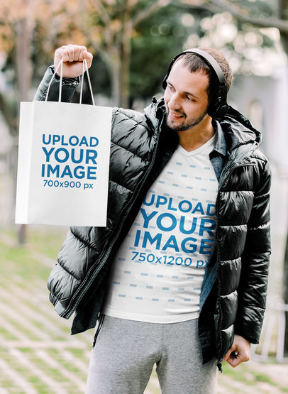 V-Neck Tee Mockup of a Smiling Man Holding a Gift Bag