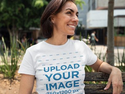Smiling Middle Aged Woman Wearing a T-Shirt Template While Sitting on a Bench