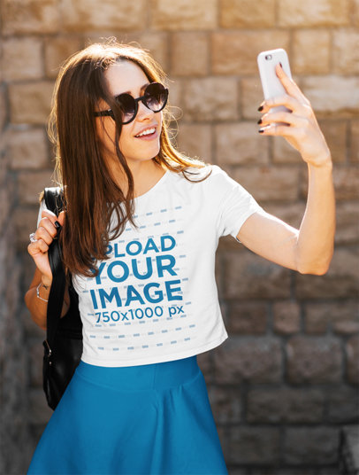Crop Top Mockup of a Female Tourist Taking a Picture With Her Phone