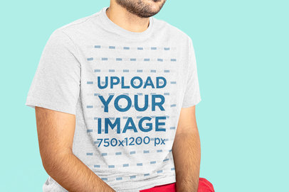 T-Shirt Mockup Featuring a Man with a Beard Sitting in a Studio