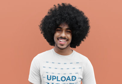 T-Shirt Mockup of a Happy Curly-Haired Man Against a Colored Backdrop